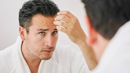 Man examining his hair loss